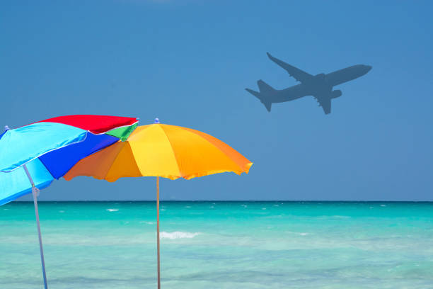 istock Colorful parasols and airplane turquoise water 965507756