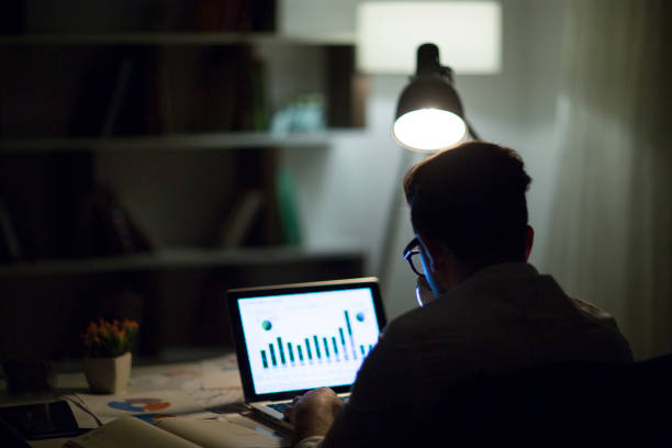 istock Man working with laptop late at night at home 965514584