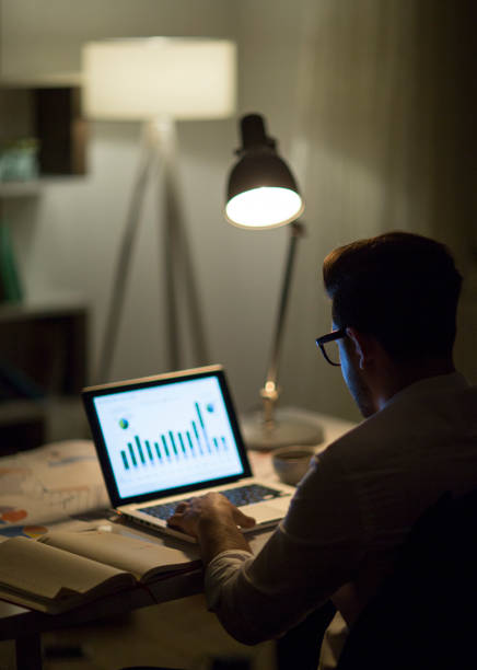 istock Man working with laptop late at night at home 965515020
