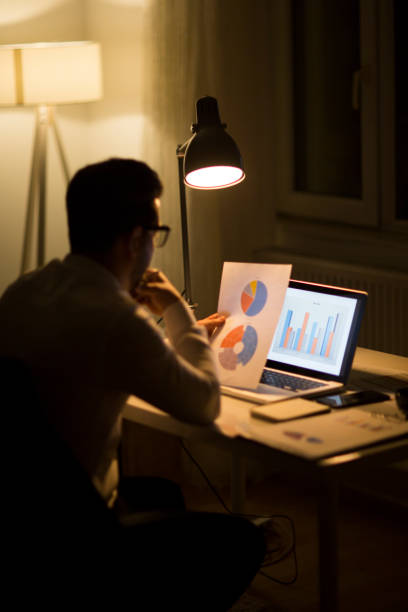 istock Man working with laptop late at night at home 965522468