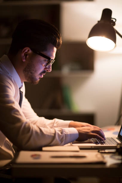 istock Man working with laptop late at night at home 965522628