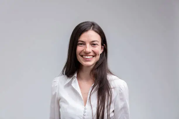 Photo of Young long-haired smiling woman in white shirt
