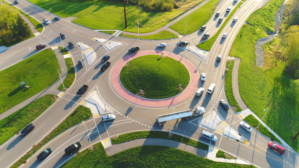 Busy city roundabout intersection at sunrise rush hour.