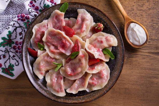 Dumplings, filled with strawberries. Pierogi, varenyky, vareniki, pyrohy - dumplings with filling Dumplings, filled with strawberries. Pierogi, varenyky, vareniki, pyrohy - dumplings with filling. View from above, top, overhead pierogi stock pictures, royalty-free photos & images