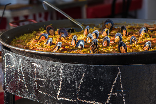 Typical spanish seafood paella in traditional pan close view. Selective focus.
