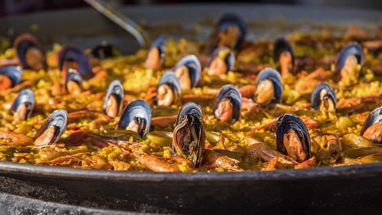 Typical spanish seafood paella in traditional pan close view. Selective focus.
