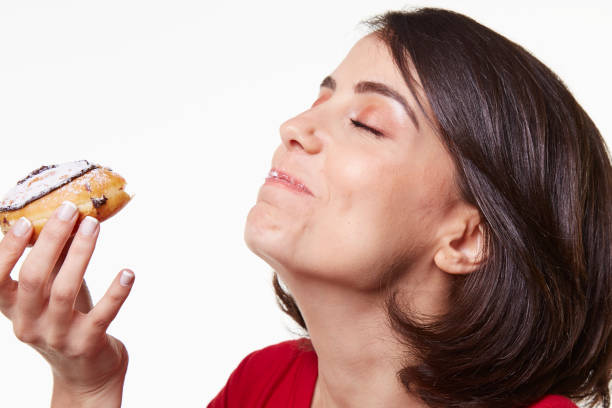 istock young woman eating a donut 965541174
