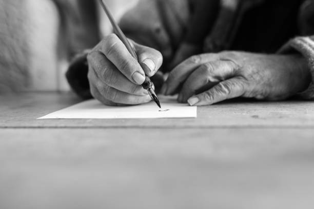niveaux de gris image d’un homme senior faisant calligraphie - writing chair photos et images de collection