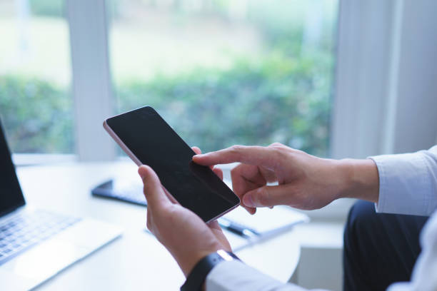 istock Man's hand working with black screen cellphone For Graphic display montage.Man typing text message on smart phone. 965547300