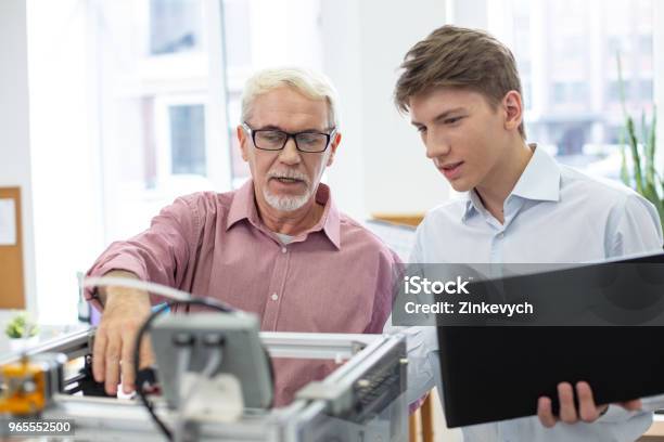 Pleasant Senior Engineer Teaching About 3d Printer Stock Photo - Download Image Now - 3D Printing, Artist's Model, Colleague