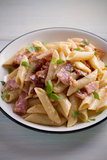 istock Penne pasta with bacon and sundried tomatoes. Alfredo penne pasta 965565420