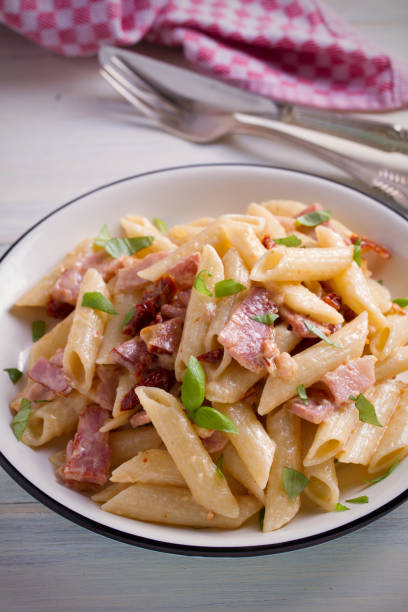 istock Penne pasta with bacon and sundried tomatoes. Alfredo penne pasta 965566678