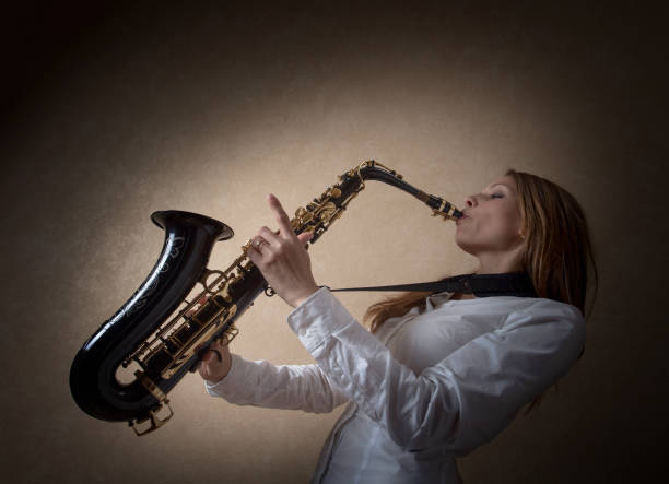 istock Young beautiful long haired blonde with saxophone. 965569296