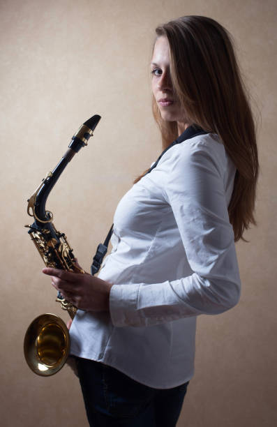 istock Young beautiful long haired blonde with saxophone. 965569312