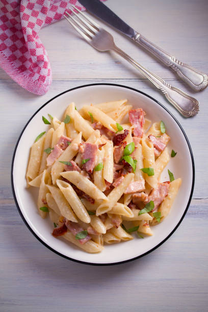 istock Penne pasta with bacon and sundried tomatoes. Alfredo penne pasta 965571684