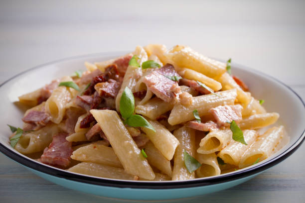 istock Penne pasta with bacon and sundried tomatoes. Alfredo penne pasta 965572382
