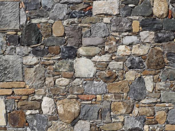istock Stone wall made of irregular natural rocks of different sizes, bricks and slabs 965575986
