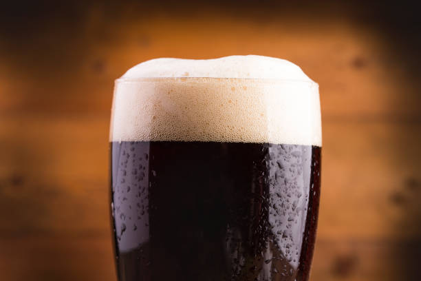 Ice cold glass of dark beer covered with water drops Ice cold glass of dark beer covered with water drops bitter stock pictures, royalty-free photos & images