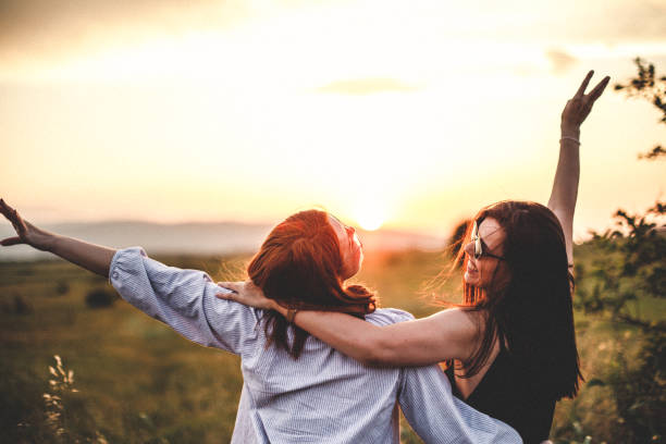 teen girls look at the sunset - girl woman imagens e fotografias de stock