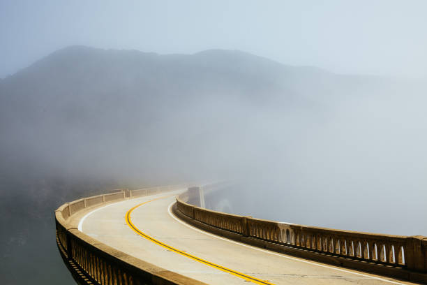 route dans le brouillard du matin - bixby bridge photos et images de collection