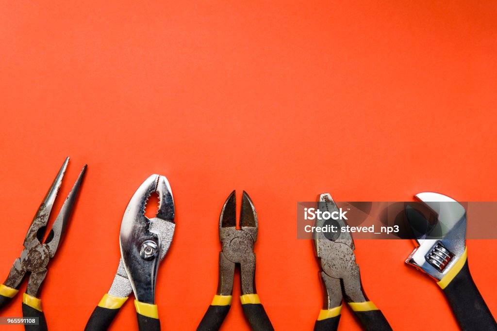 Various Used Pliers Tools Various Used Pliers Tools on a orange textured background with space for text Toolbox Stock Photo