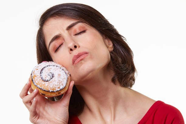 istock young woman eating a donut 965591640