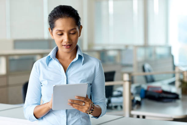 istock Young businesswoman using tablet PC in office 965602132