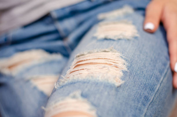 istock Woman in torn jeans macro blue texture 965603410