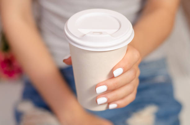 istock Woman sitting drinks cardboard glass cup coffee 965603518