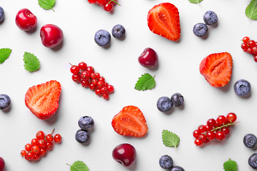 Fruit pattern on a white background (strawberry, blueberry, red currant, cherry). Top view