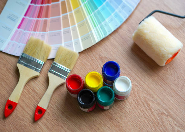 istock Painter and decorator work table with house project, Color swatches, Painting roller and paint brushes 965647638