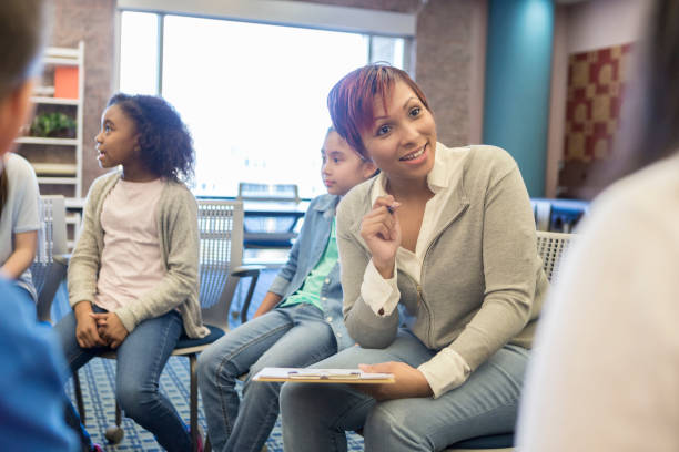 istock Attentive therapist talks with group of students 965665316