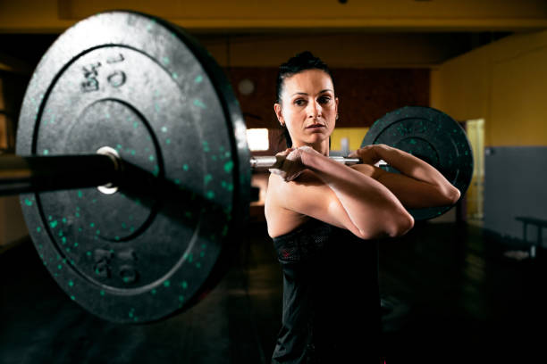 istock Exercise with heavy weight, muscular girl holding weights and training hard 965666220