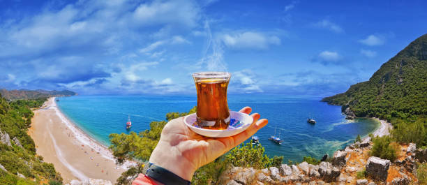 Morning cup of tea with view of colorful panoramic Olympos beach stock photo