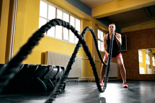 istock Woman training with battle ropes in gym 965668532