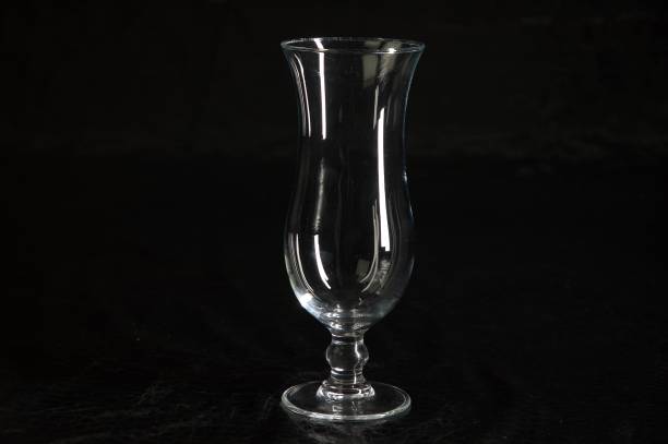 istock Still life with one empty single modern transparent and fragile (cocktail) glass on a table with a black background 965668978