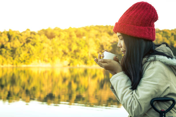 istock Woman Having Drink At Riverbank 965669370