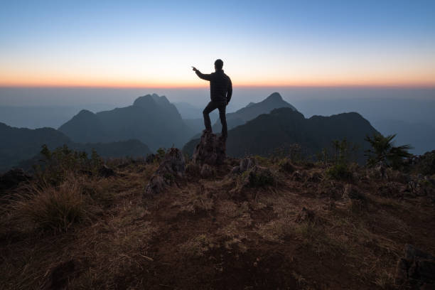 istock Rear View Of Man Standing On Mountain Against Sky During Sunset 965670944