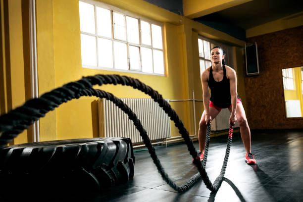 istock Woman training with battle ropes in gym 965673872