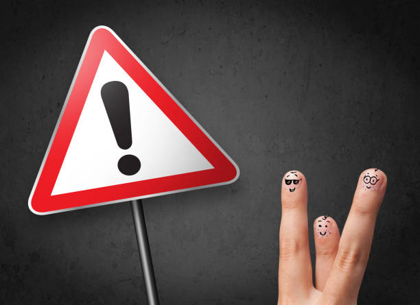 istock Happy smiley fingers looking at triangle warning sign with exclamation mark 965686828
