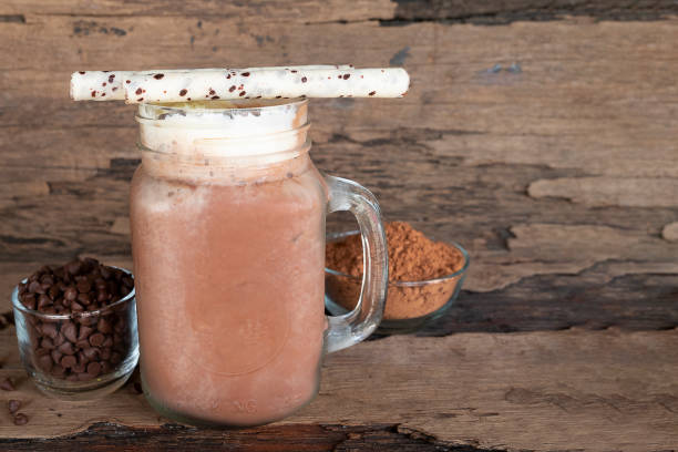 istock Chocolate and cocoa mixed with milk smoothies on wooden floor. 965690630