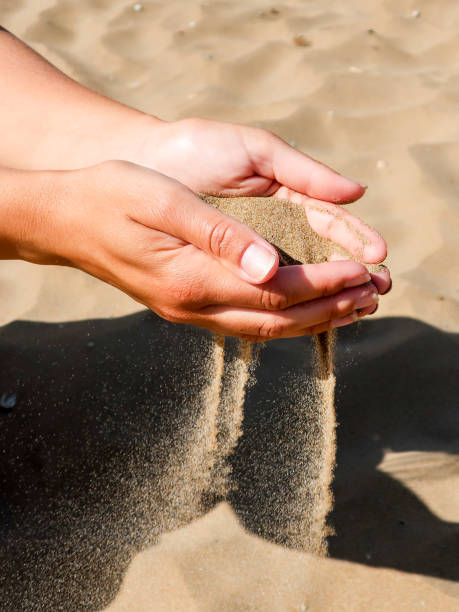 istock Woman's hands holding and pouring sand 965711288