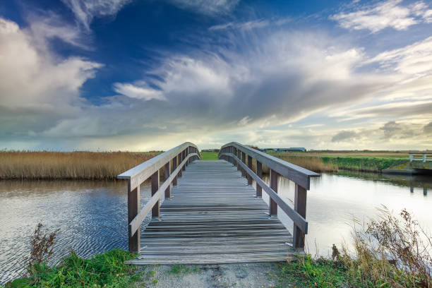 istock wooden bridge via river and blue sky, Netherlands 965718714