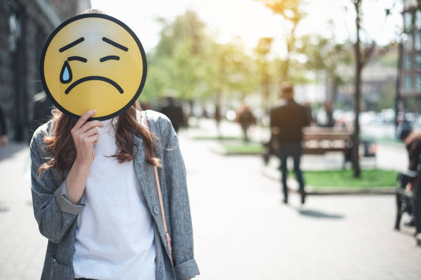 femme tient pleure face signe extérieur - sadness human face depression smiley face photos et images de collection