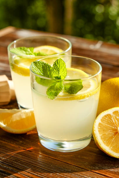istock Rustic composition with freshly squeezed homemade cold lemonade in bottle and glasses with condensation droplets. 965723990