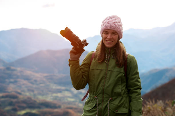 istock Woman in autumn clothes with camera 965724070