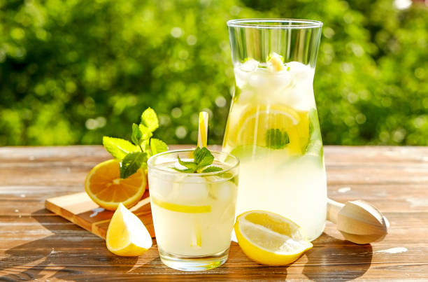 istock Rustic composition with freshly squeezed homemade cold lemonade in bottle and glasses with condensation droplets. 965724156