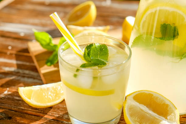 istock Rustic composition with freshly squeezed homemade cold lemonade in bottle and glasses with condensation droplets. 965724254