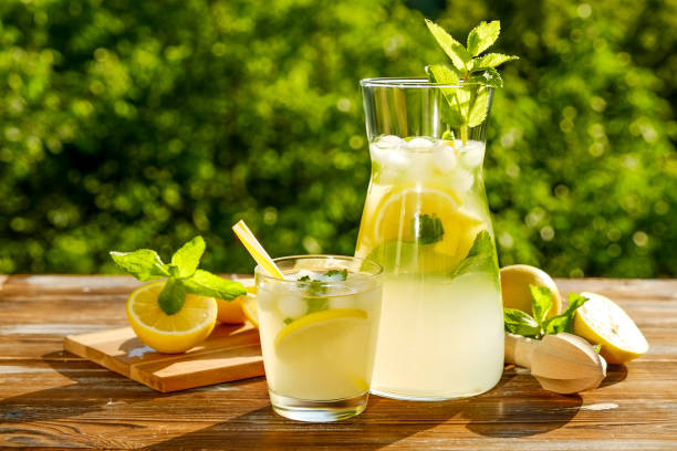 istock Rustic composition with freshly squeezed homemade cold lemonade in bottle and glasses with condensation droplets. 965724332