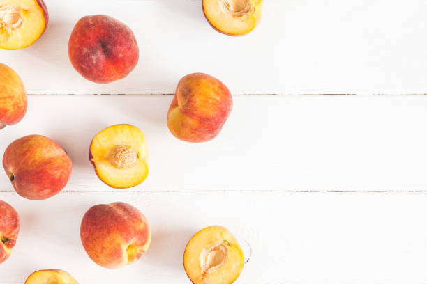 istock Peaches on white wooden background. Flat lay, top view 965724852